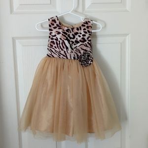 Little girls dress with fabric flower detail at waste and tool skirt.